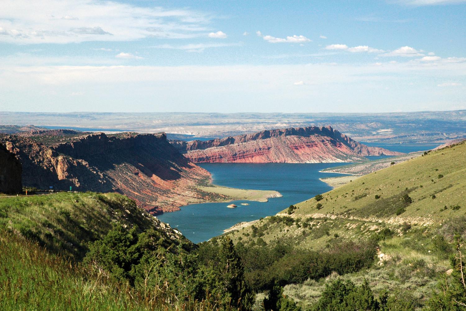 Red cliffs above the blue water of Flaming Gorge in evening light.